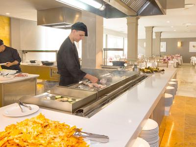 Profesionální kuchyně s kuchařem připravujícím jídla v moderní restauraci.