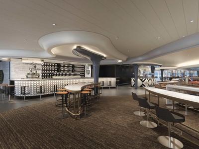 Modern bar interior with curved ceiling detail, stools, and tables in a spacious setting.