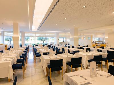 Bright restaurant with many tables and white tablecloths in a modern design.