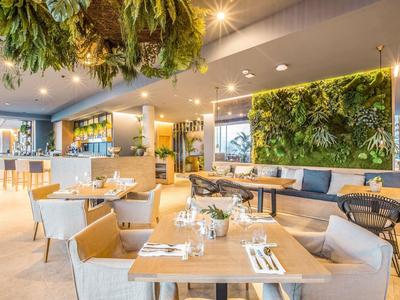 Světý hotelový pokoj s velkou postelí, balkonem a výhledem na moře.