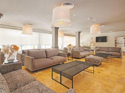 Lichte lounge met grijze banken, glazen tafels en houten vloer in moderne stijl.