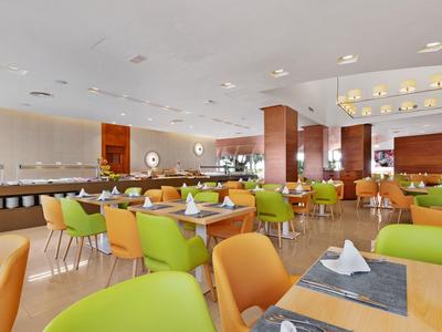 Bright modern restaurant with colorful chairs and large windows.