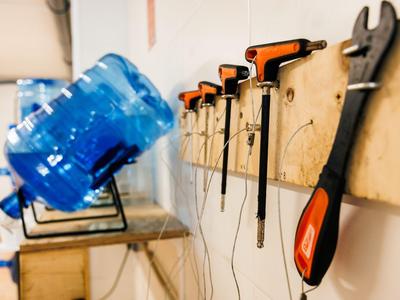 Herramientas y botella de agua en un taller con destornilladores y alicates en la pared