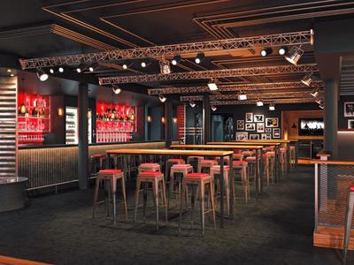 Moderní hotelový bar s vysokými stoly, červenými barovými židličkami a atmosférickým osvětlením.