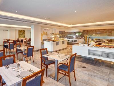 Moderner Frühstücksraum mit eleganten Holztischen und Stühlen sowie Buffetbereich