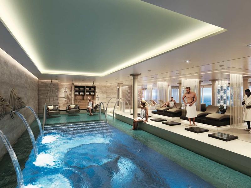 Moderner Wellnessbereich mit Indoor-Pool, Wasserfällen, Liegen und Menschen in weißer Kleidung.