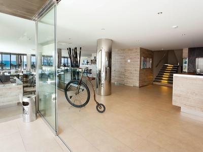 Moderne hotelhal met glazen wand, fietsenrek en receptiebalie.