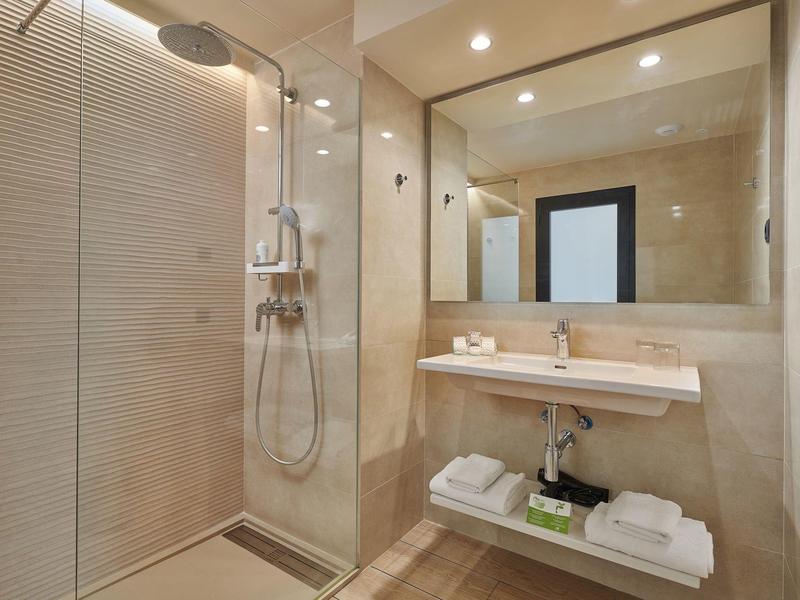 Moderne douche en wastafel in een stijlvolle, lichte badkamer met grote spiegel.