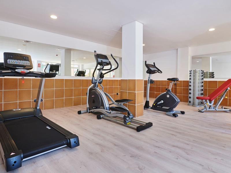 Lichte fitnessruimte met loopband, crosstrainer, hometrainer en krachtstation.