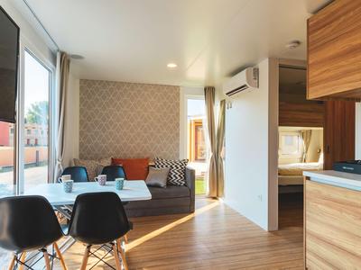 Modernes Hotelzimmer mit Sitzbereich, Essbereich und Holzakzenten.