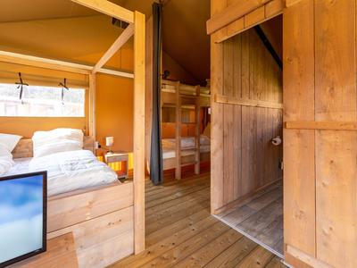 Gemütliches Holzferienhaus mit Betten und Etagenbett, geeignet für Urlaub und Entspannung.