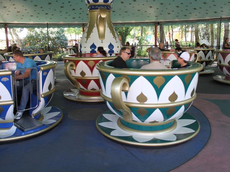 Menschen fahren in einer großen Teetasse auf einem Karussell im Freizeitpark.