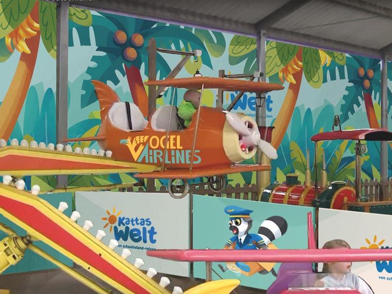 Bunte Innen-Spielplatz-Szene mit Rutschen und hängenden Tierfiguren in einer Halle.