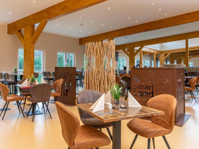 Moderner, heller Essbereich mit Holzakzenten und bequemen Stühlen in Hotelrestaurant.