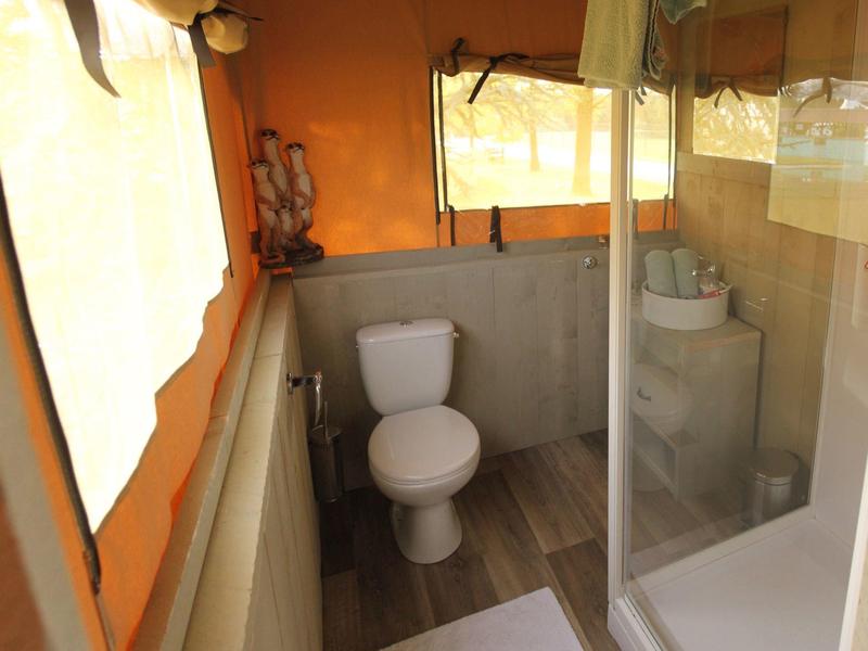 Kleine Badezimmer mit Toilette, Waschtisch und Dusche mit Glasabtrennung.