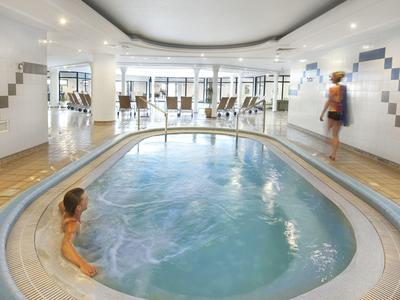 Binnenzwembad in een hotel met kinder- en volwassenengedeelte en een moderne sfeer.