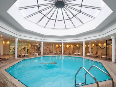 Innenraum eines runden Schwimmbads mit Glaskuppel und Wänden in hellem Beige.