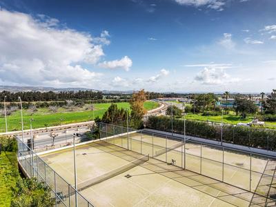 Vue d'un terrain de volley-ball avec une clôture autour et un paysage vert en arrière-plan