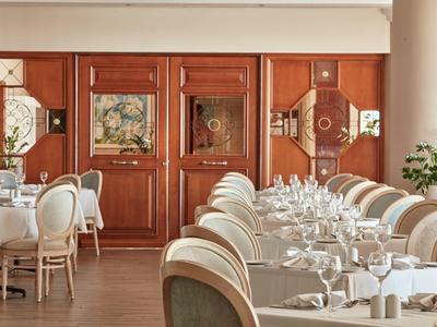 Elegantes Restaurant mit gedeckten Tischen, Holzpaneelen und Kunst an den Wänden.