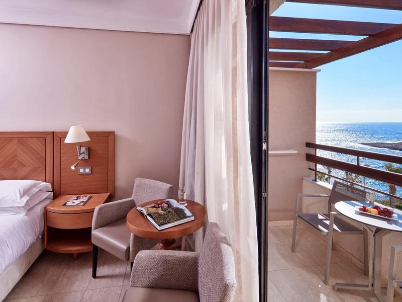 Gemütliches Hotelzimmer mit Zugang zu Balkon und Meerblick.