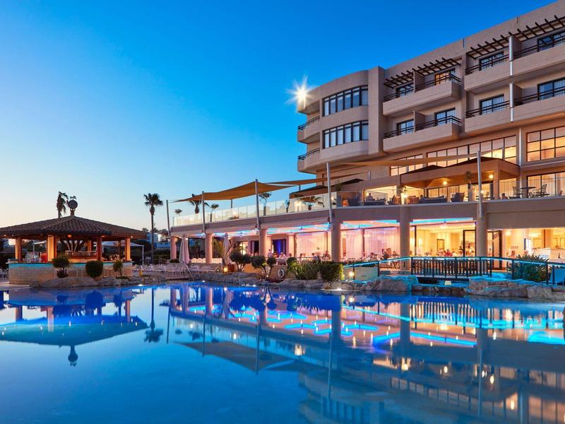 Modernes Hotel mit beleuchtetem Pool und Terrasse bei Abenddämmerung