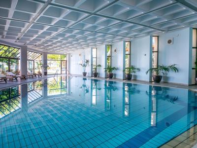 Innenpool in einem Hotel mit hellem Licht und Pflanzen an den Wänden