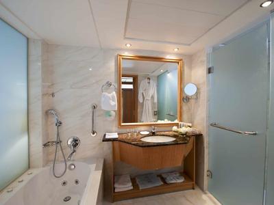 Bagno moderno con vasca, lavabo, grande specchio e doccia in vetro.