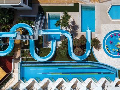 Vista aerea di un parco acquatico con scivoli, piscine e un'area piena di palline colorate.