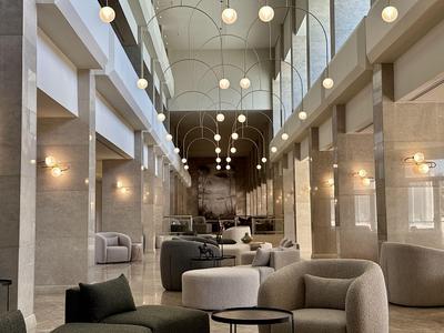 Moderne hotel lobby met hoge plafonds, grote ramen en comfortabele zitgedeeltes.