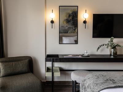 Moderne Hotellobby mit bequemen Sitzgelegenheiten und elegantem Wanddekor in neutralen Farben.