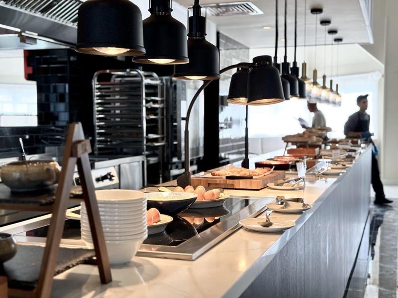 Buffet mit gedecktem Frühstückstisch, Brot und Backwaren in modern eingerichteter Küche.