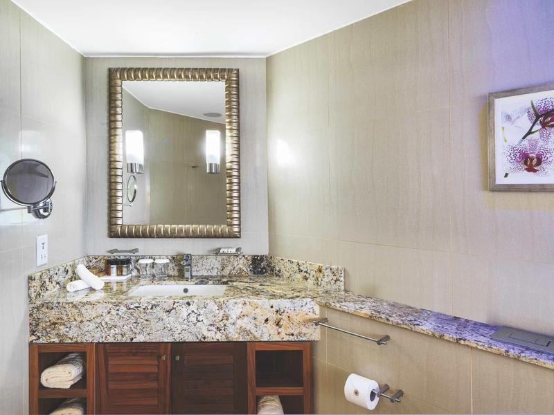 Moderne Badezimmerecke mit Marmor waschtisch, großem Spiegel und hellen Wänden.