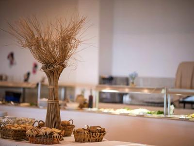 Ein Tisch mit Getreidebündel und Körben vor einem Buffet mit warmem Licht.