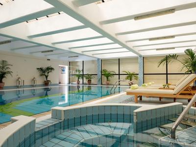 Helles Hallenbad mit Liegestühlen und Pflanzen für entspannte Urlaubstage.