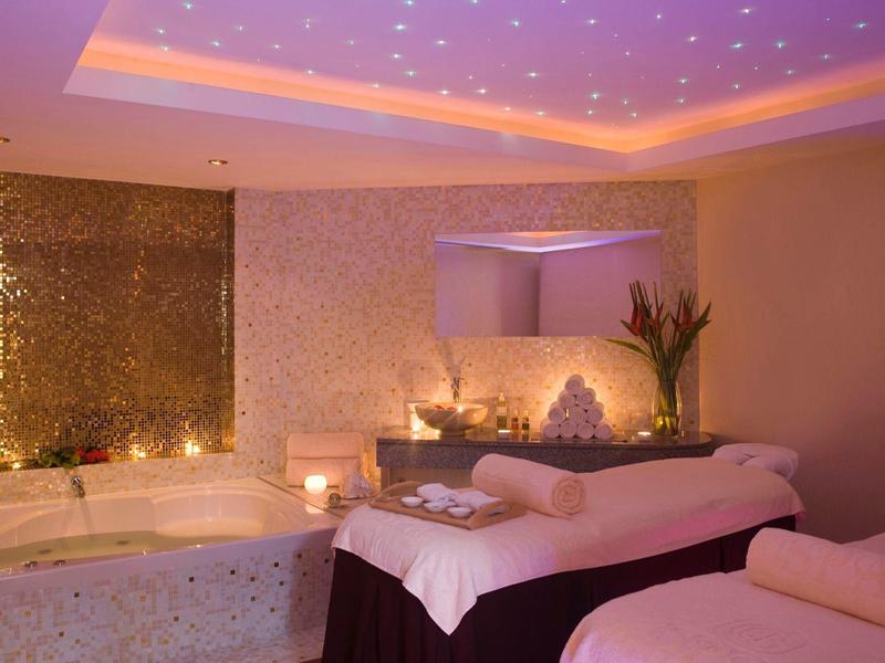 Entspannender Wellnessraum mit Massagebänken, warmem Licht und stilvoller Dekoration.