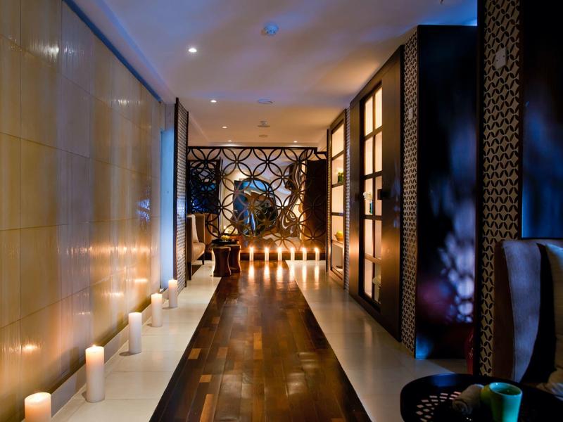 Flur mit dunklem Holzfußboden, Kerzenlicht und dekorativen schwarzen Trennelementen.