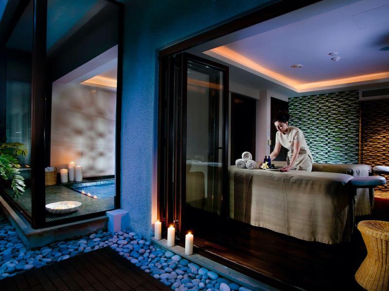 Moderne Wellness-Oase mit Massagebank, Kerzenlicht und ruhiger Atmosphäre bei Abenddämmerung.