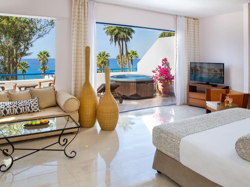 Helles Hotelzimmer mit Meerblick, gemütlichem Sofa und Doppelschlafzimmer.