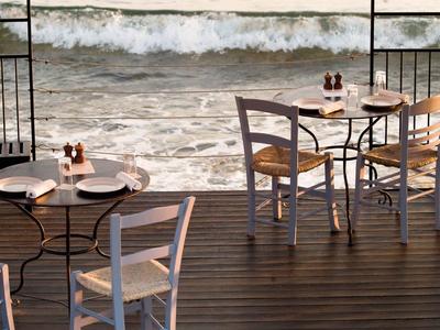 Terraza con mesas preparadas con vistas al océano con olas