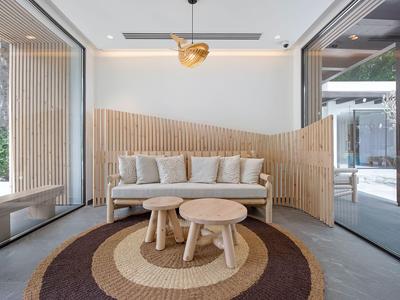 Modernes Wohnzimmer mit Sofa, zwei runden Tischen und rundem Teppich in neutralen Farben.