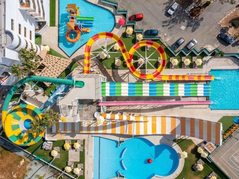 Bunte Wasserrutschen und Pools in einem Freizeitpark aus der Vogelperspektive.