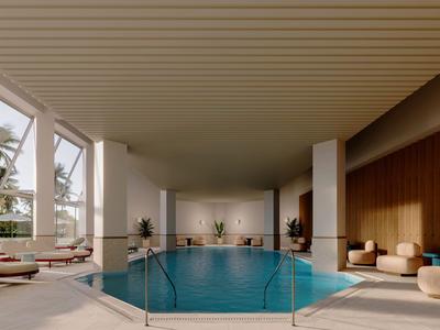 Piscina interior en una habitación de hotel moderna con grandes ventanas y asientos cómodos.