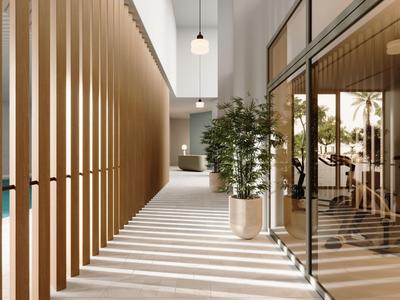 Pasillo moderno de hotel con paneles de madera, paredes de vidrio y una maceta grande cerca de la entrada.