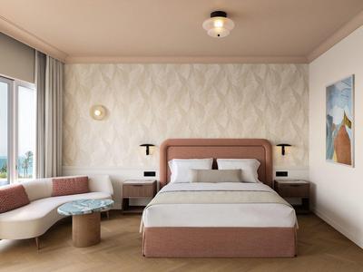 Modernes Schlafzimmer mit großem Bett, Ecksofa und Fenster mit viel Tageslicht.