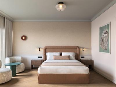 Modernes Hotelzimmer mit großem Bett, Sitzecke und Kunst an der Wand.