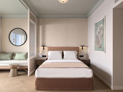 Modernes Hotelzimmer mit Doppelbett, Sofa, Wandbild und runder Wandspiegel