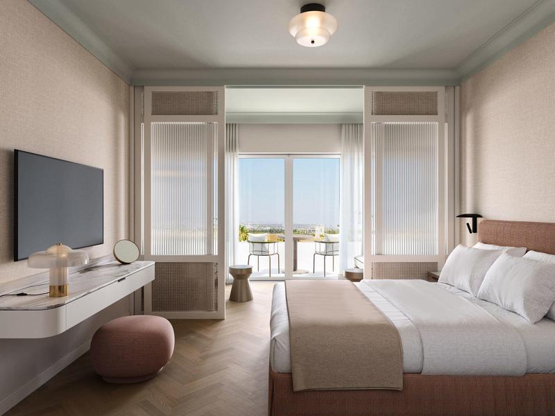 Modernes Hotelzimmer mit Doppelbett, Schreibtisch, Fernseher und Balkon mit Meerblick.