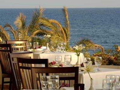 Terrazza con tavoli apparecchiati e vista mare in una giornata di sole