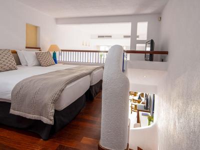 Modernes Hotelzimmer mit zwei Einzelbetten, Holzfußboden und minimalistischer Einrichtung.