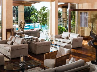 Modernes Wohnzimmer mit beigen Sofas und Blick auf einen Pool im Freien